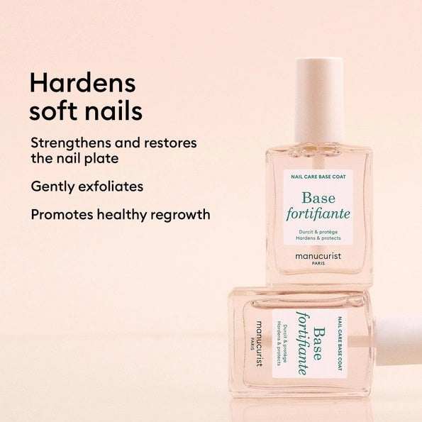 A clear bottle of MANUCURIST INC MANUCURIST - FORTIFYING BASE COAT vegan nail care, featuring a white cap and green lettering on the label, designed as a nourishing base to strengthen nails and promote healthy growth.