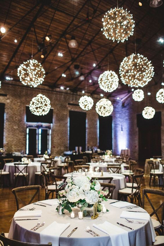 The PRE-LIT GRAPEVINE BALL - 12 INCHES by EGRAPEVINESTORE features intertwined brown branches with small warm white LED lights, creating a dense and textured appearance while adding a festive and cozy glow.