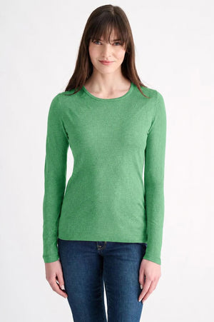 A woman with straight dark hair wears the KINROSS CASHMER Long Sleeve Crew Neck Silk Cashmere Sweater in light blue and white pants, standing against a plain light background with one hand in her pocket, looking at the camera.
