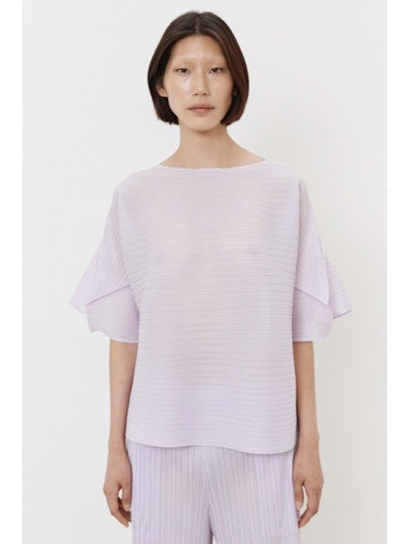 The MEIMEIJ - PLISSE TOP from MEIMEIJ showcases a dark fabric with a fine weave pattern, offering a subtle grid-like texture. Its deep black color embodies elegance and simplicity, perfect for minimalist fashion.