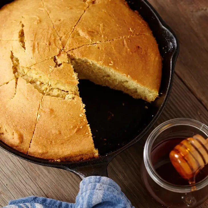The bright yellow-orange bag, labeled &quot;CUP4CUP GLUTEN FREE CORNBREAD,&quot; showcases an image of cornbread in a skillet with a slice cut out. This non-GMO mix, confirmed to be gluten free below the title, displays weight details: &quot;Net Wt. 1lb (453.6g).