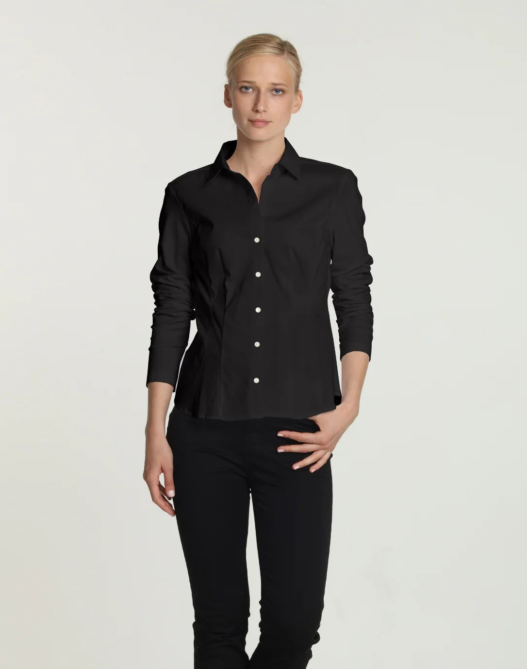 A person with blond hair in a bun is wearing the HINSON WU - JAMIE LONG SLEEVE “T” SHIRT IN BLACK, standing against a plain white background. Looking at the camera with a relaxed posture, the individual showcases an ensemble by HINSON WU that exudes refined style while ensuring comfort.