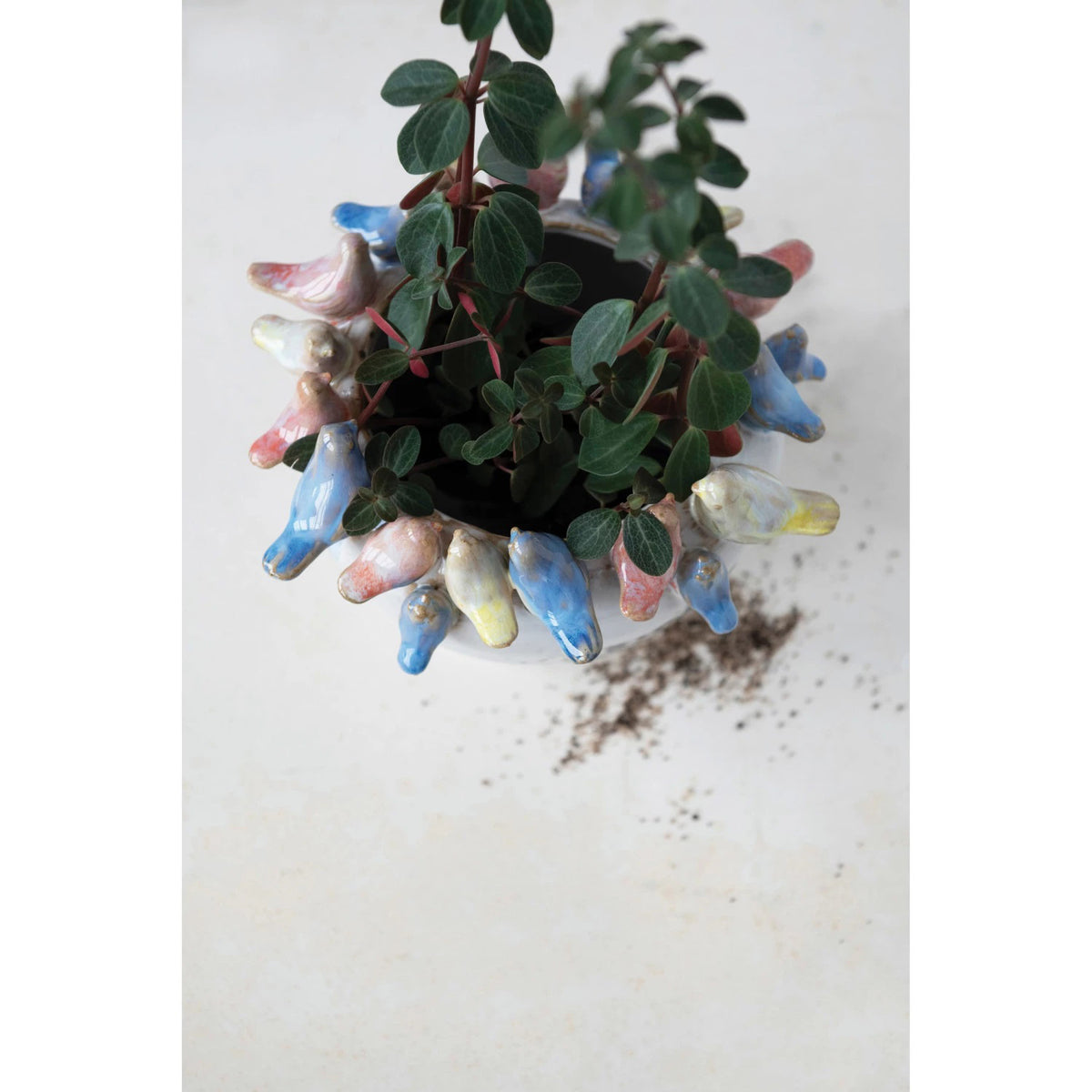The PLANTER W BIRDS ON RIM by CREATIVE COOP is a ceramic piece made entirely from stoneware, showcasing a smooth, white exterior with small pastel-colored bird sculptures—yellow, pink, and blue—gracefully adorning the rim.