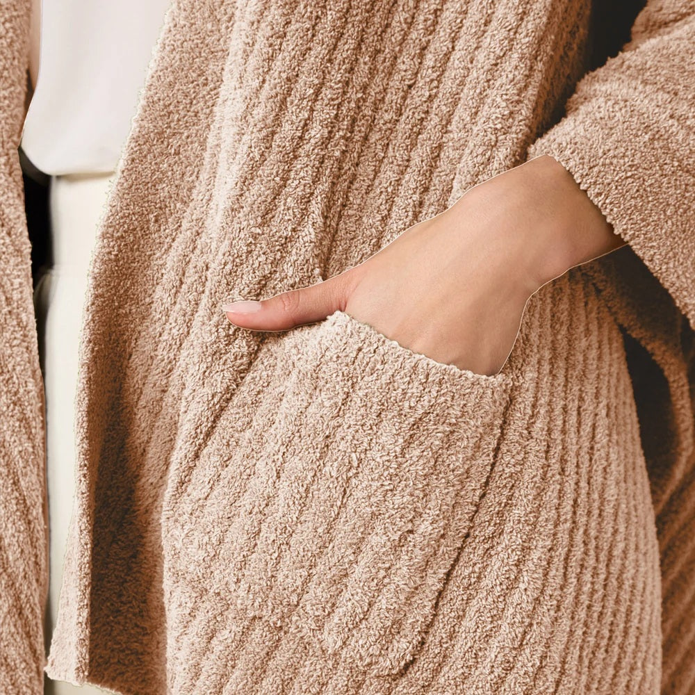 A woman wearing a black SOFTIES - SOLID RIB MARSHMALLOW SHAWL over a grey top and white trousers.