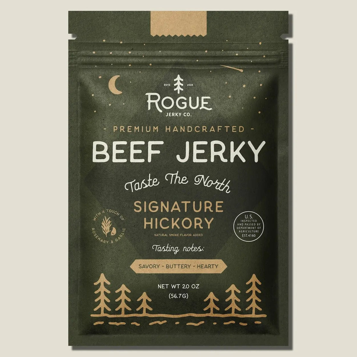A dark green pouch of ROGUE JERKY - HICKORY BEEF JERKY by ROGUE JERKY CO., featuring forest and moon imagery, labeled “Premium Handcrafted” and “Taste The North.” This savory, buttery, hearty sugar free jerky is an ideal keto friendly snack. Net weight: 2 oz.