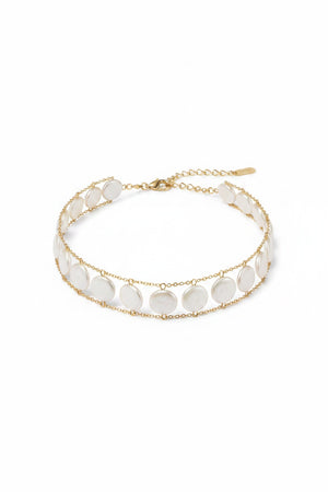 A woman wears the GOLDISH - LADDERS TO BLISS WHITE PEARL CHOKER by GOLDISH, a double-layered lightweight necklace with round white pearls on a gold linked chain, shown against a neutral background.