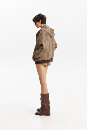 The ELEH - FIRENZE HOODED BOMBER by ELEH is a brown jacket with a classic check pattern, zip-up front, long sleeves, and ribbed cuffs and hem, displayed against a plain white background.