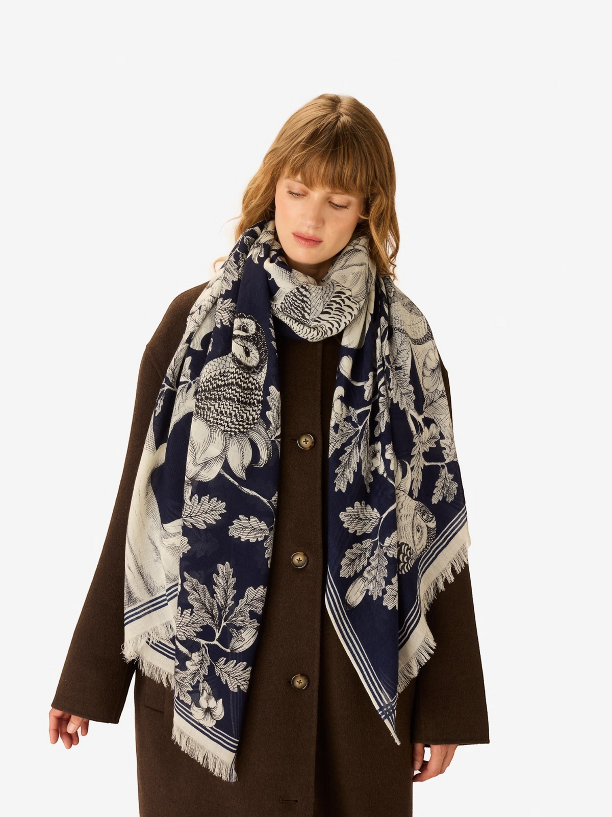 The INOUI EDITIONS - ARCHIMEDE WOOL SCARF IN NAVY by INOUI is crafted in India and features a detailed tree adorned with numerous birds and flowers on its branches, set against a white background.