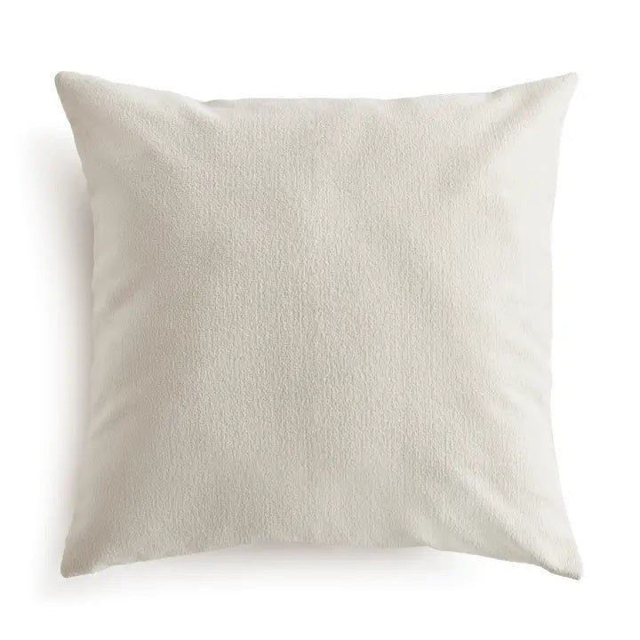 The NAPA HOME AND GARDEN - COOPER SQUARE OUTDOOR PILLOW 24&quot; is a plain, light beige cushion with soft, textured recycled fabric. Plush and comfortable, it&#39;s ideal for sofas or beds. Shown against a white background.