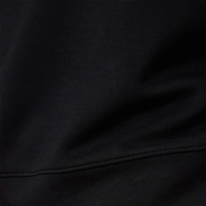 A woman wears a SOFTIES - DREAMTECH BOAT NECK WITH PINTUCK PANT SET in olive green, featuring a long-sleeve boat neck top and matching wide-leg pintuck pants.