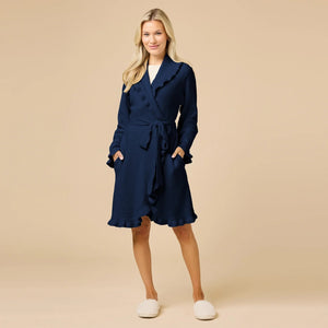 A woman wearing a SOFTIES - RUFFLE CHENILLE ROBE 36″ IN MIDNIGHT, a knee-length navy blue chenille robe with cascading ruffle trim.