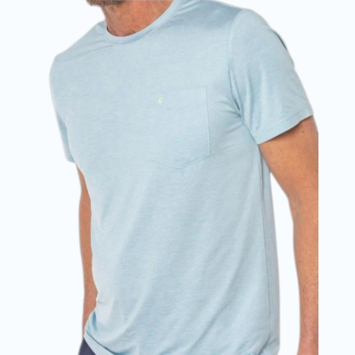 A man wearing the CRIQUET - PERFORMANCE SPORT MESH T-SHIRT IN LIGHT BLUE by CRIQUET, classic fit with short sleeves and a chest pocket. The cropped image shows only his upper body against a plain white background.