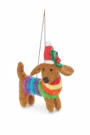 A FESTIVE RAINBOW PRIDE DOG ORNAMENT shaped like a needle felted dachshund wearing a rainbow-striped sweater, a Santa hat, and a holly sprig.