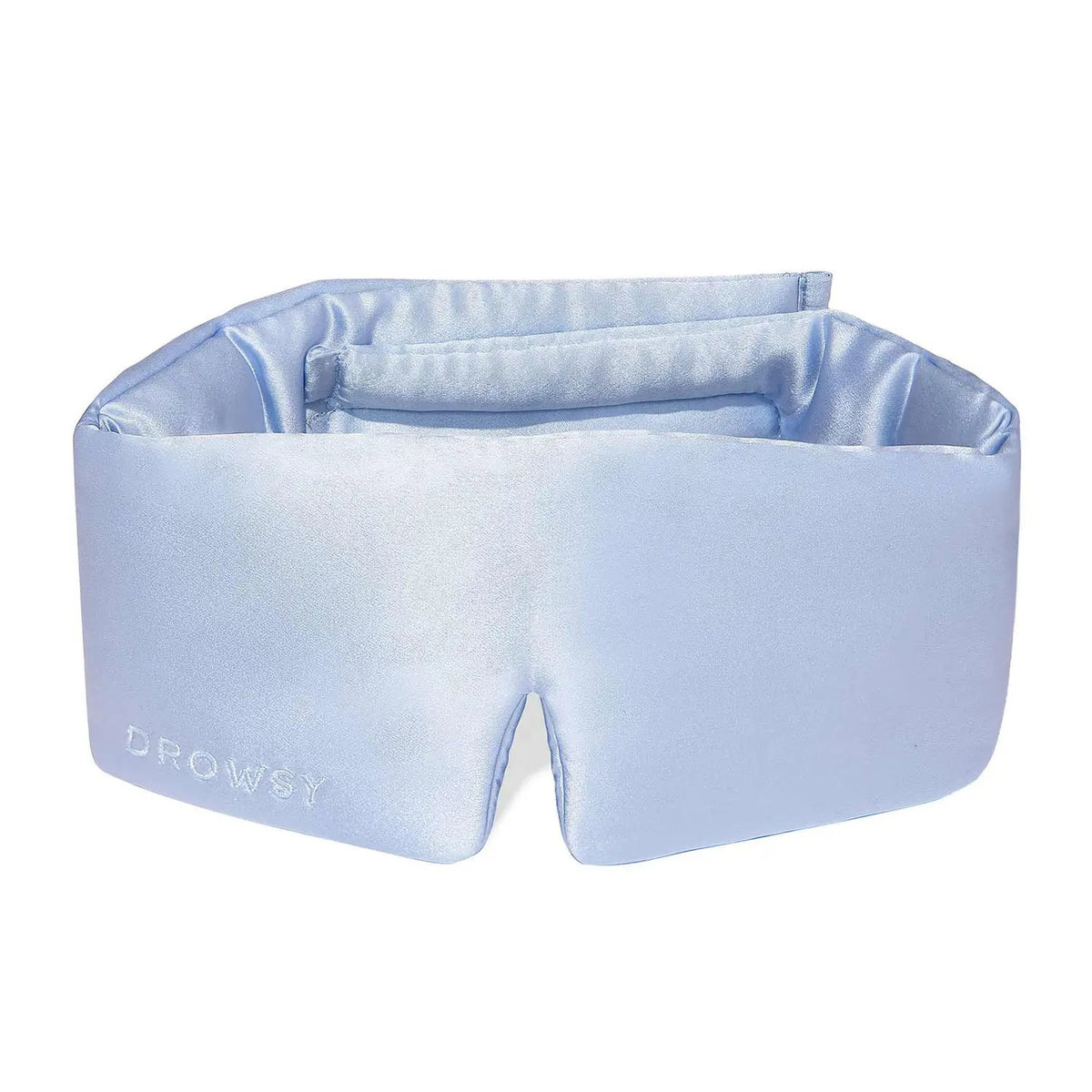 A person wearing a white tank top is lying on a pillow with the DROWSY - SATIN SLEEP MASK by DROWSY SLEEP CO covering their eyes. They look relaxed, enjoying beauty sleep as their hand rests gently on the pillow.