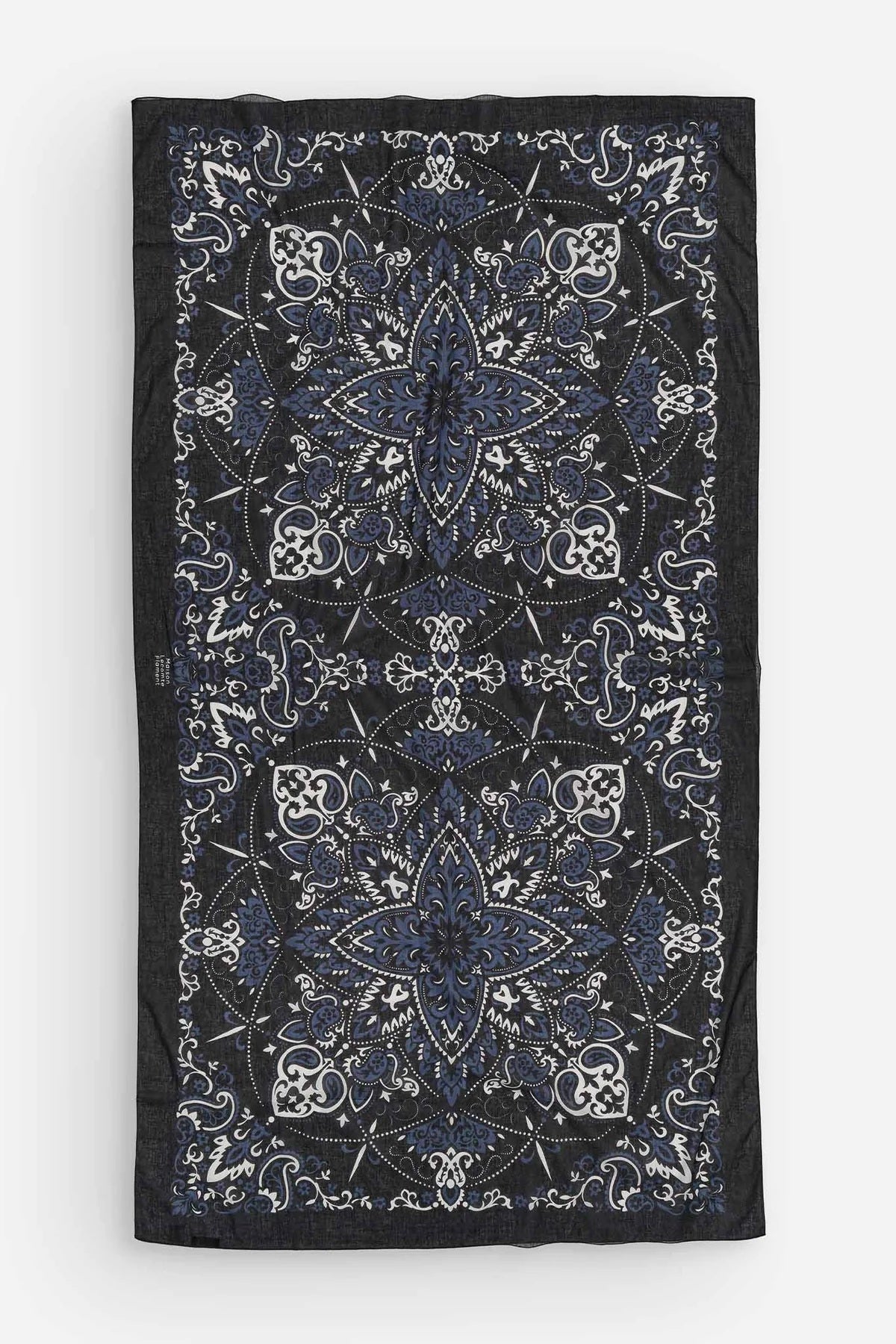 The MAISON LECOMTE - COSTA BRAVA BLACK SARONG by MAISON LECOMTE FLAMENT, featuring a white and blue paisley pattern, is tied in a loose knot against a plain white background.