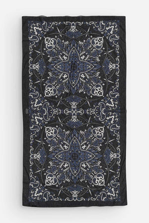 The MAISON LECOMTE - COSTA BRAVA BLACK SARONG by MAISON LECOMTE FLAMENT, featuring a white and blue paisley pattern, is tied in a loose knot against a plain white background.