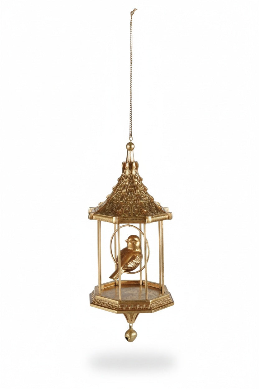 A gold-colored, pagoda-style CREATIVE COOP BIRD IN BIRDCAGE ORNAMENT WITH BEAD, containing a small bird, hanging from a metal chain with a decorative bead at the bottom.