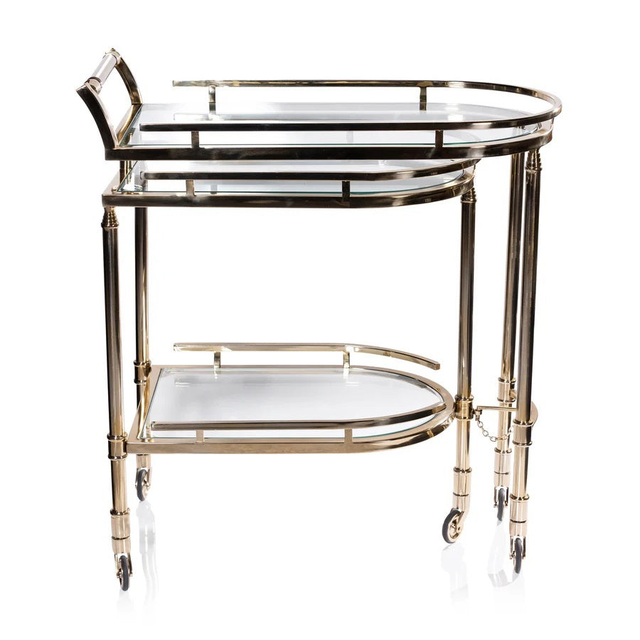 The SPIGA GOLD BAR CART by ZODAX features a vintage Italian-inspired design with elegant gold framing, mirrored glass shelves on both tiers, and smooth-rolling four-wheel mobility. Displayed against a white background, this piece is both stylish and functional.