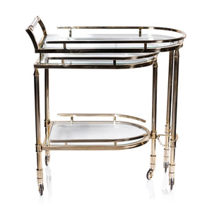 The SPIGA GOLD BAR CART by ZODAX features a vintage Italian-inspired design with elegant gold framing, mirrored glass shelves on both tiers, and smooth-rolling four-wheel mobility. Displayed against a white background, this piece is both stylish and functional.