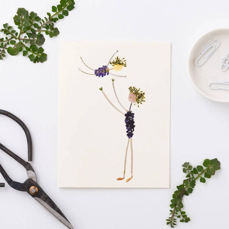 The PETAL PEOPLE PRESS Father's Day card shows a whimsical illustration on FSC-certified cardstock with two figures made of pressed flowers and leaves. The taller figure lifts the smaller one, both featuring leafy limbs and bodies adorned with vibrant purple flowers.