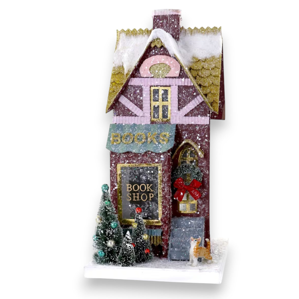 The CODY FOSTER BOOK SHOP HOLIDAY HOUSE is a festive miniature decorated with snow, trees, a wreath, and a cat figurine. The “BOOK SHOP” sign and gold shingled, snow-dusted roof make it the perfect collectible or holiday gift.
