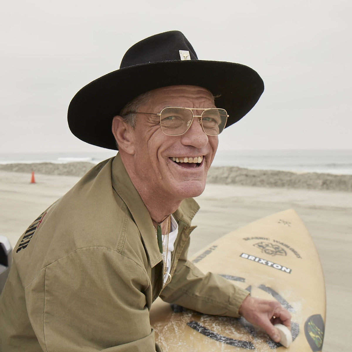 The CADDIS - HOOPER READERS feature square aviator-style frames made from lightweight gold metal, paired with scratch-resistant green-tinted lenses. Clear nose pads ensure comfortable wear, while the dark-finished arms elegantly contrast against a plain white backdrop.