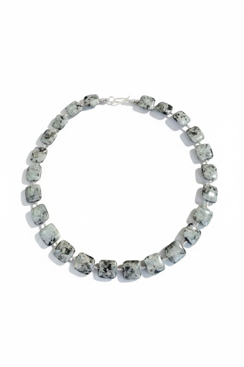 The ANN LIGHTFOOT Square Larvikite Ras Du Cou Necklace 18″ showcases elegant, marbled gray and black larvikite square gemstone beads, beautifully strung together and completed with a refined sterling silver clasp.