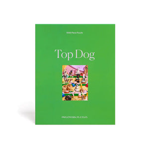 The "Top Dog" by Piecework Puzzles is a green box containing a 1000-piece puzzle. It showcases various colorful dog illustrations, offering the perfect challenge for canine enthusiasts.