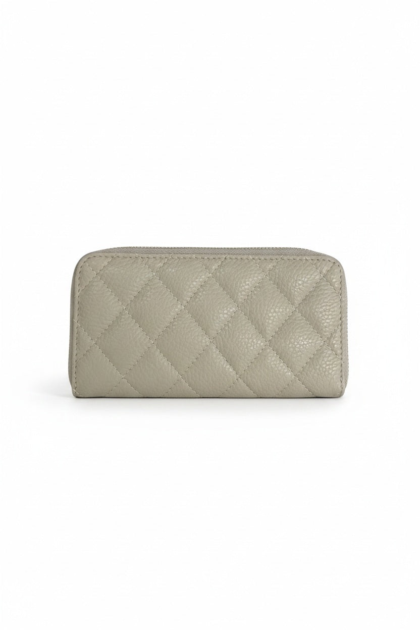 A light blue LE BORSETTE LEATHER QUILTED WALLET with diamond stitching on a white background features a zip-around closure, gold zipper pull, and multiple card slots.