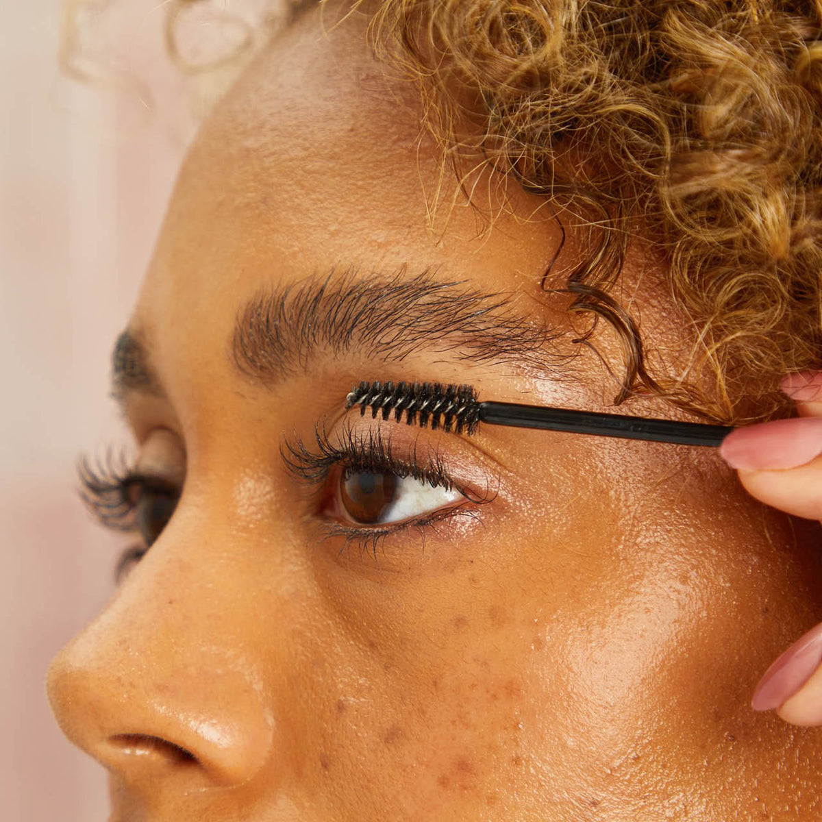 A brown glass bottle labeled "KITSCH - 100% CASTOR OIL" is set between a black mascara wand and a clear oil dropper. Renowned for supporting hair growth and moisturizing cuticles, this beauty essential is displayed on a plain white background.