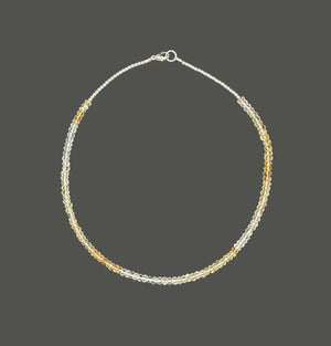 The ANN LIGHTFOOT - FACETED CITRINE RAS DU COU NECKLACE features faceted citrine stones with alternating silver and gold beads in a symmetrical design, secured by a sterling silver clasp, shown on a plain white background.