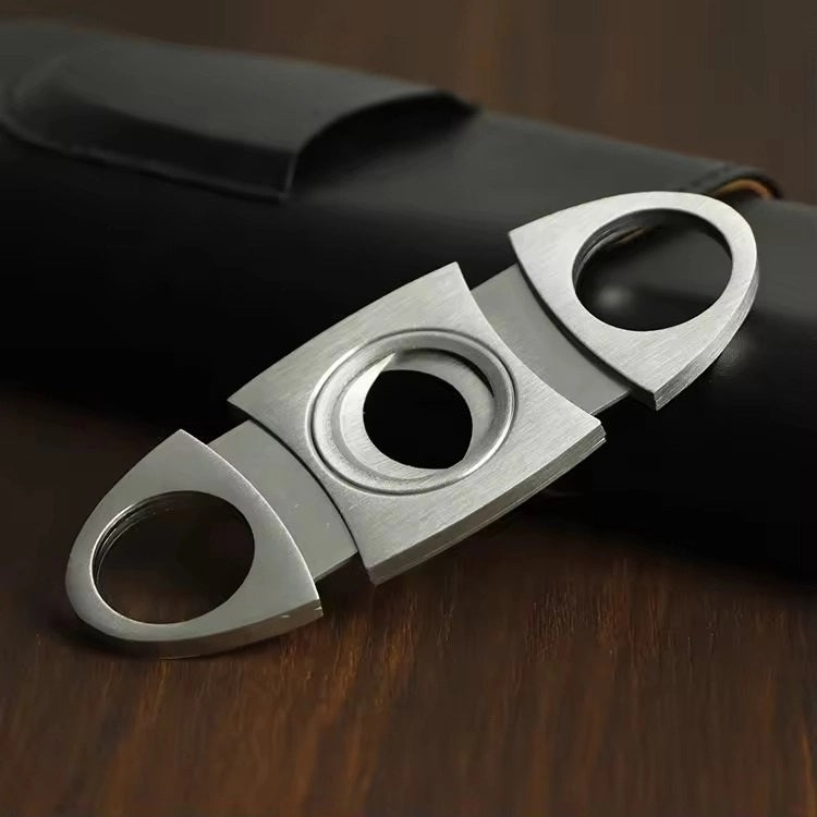 The AMERICAN LEATHER GOODS Leather Cigar Case with Wood-Lined Humidor and Cutter in Black rests on a wooden surface, with another travel humidor case in brown visible in the background.