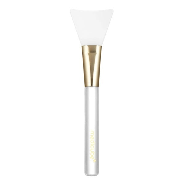 The MEDICUBE - JELLY BRUSH MASK APPLICATION TOOL by KOSMIC KBEAUTY SKINCARE is a hygienic mask applicator designed with a clear handle, gold ferrule, and a flexible, flat white silicone tip—making it the perfect tool for smooth and mess-free skincare routines.