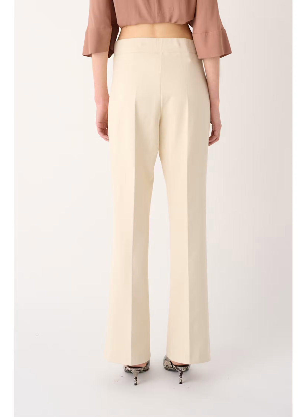 Back view of a person wearing a mauve, short-sleeved top and MEIMEIJ - PULL ON PANT IN SUGAR SWIZZLE, which are cream-colored, flared-leg trousers designed for tailored comfort.