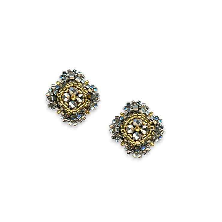 A pair of stud earrings from MIGUEL ASES, INC., featuring diamond-shaped mosaics made of tiny pyrite Miyuki beads in shades of gold, silver, and bronze. The beads are meticulously arranged tightly to create a complex geometric pattern against a white background, perfectly capturing the exquisite artistry seen in Miguel Ases jewelry.