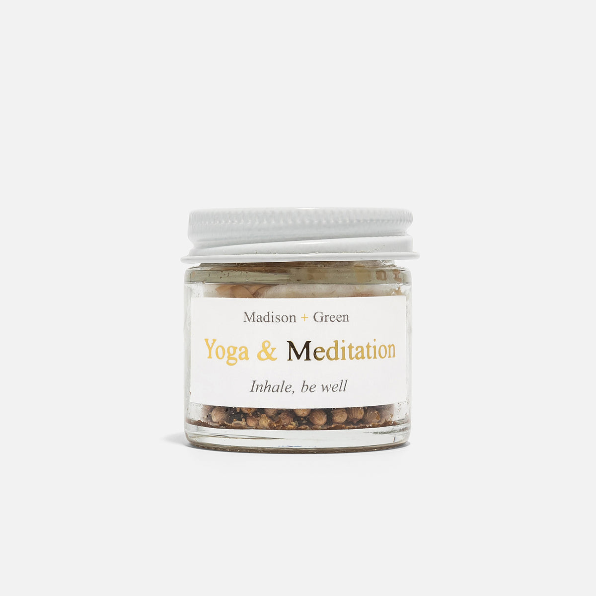 A MADISON GREEN Yoga and Meditation Spiritual Aromatherapy Inhaler rests on a white surface, its cap open nearby. Soft shadows surround the calming product, evoking peacefulness after meditation.