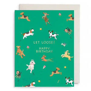 The E. FRANCES - OFF LEASH BIRTHDAY CARD by E. FRANCES PAPER features playful cartoon dogs, toys, and treats with "LET LOOSE! HAPPY BIRTHDAY" in gold foil and comes with a white envelope.