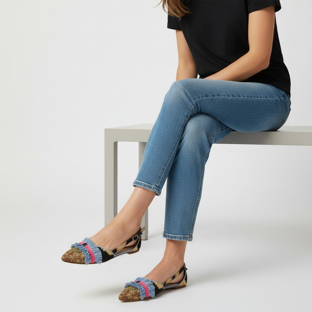 The MEHER KAKALIA GRETA SLINGBACK BLACK BEIGE TO MUDROSE flats feature hand-dyed leather panels, embroidered details, blue and pink fringe accents, a pointed toe, and a low heel for a colorful summer look.