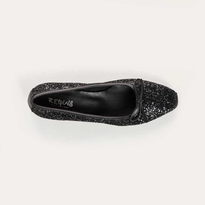 A single REQINS - FETICHE GLITTER HEELED BALLERINA shoe, black and covered in glitter, viewed from above with a small bow on the toe and &quot;REQINS&quot; on the insole—perfect elegant party shoes.