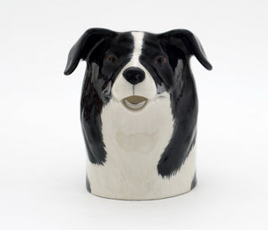 The QUAIL DESIGNS QUAIL CERAMICS Border Collie Jug is a handpainted stoneware jug shaped like a black and white dog, with the spout as the dog's open mouth, shown on a plain white background.