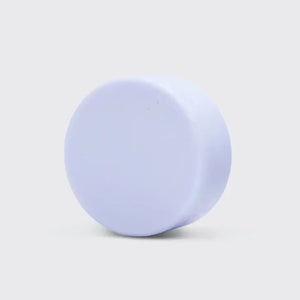 A KITSCH Purple Toning Solid Conditioner Bar sits on its packaging, which states it's formulated with Biotin for blonde and highlighted hair, neutralizing brassiness. The labels affirm it's color safe, pH balanced, and vegan.