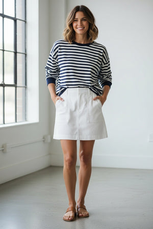 The FRANK & EILEEN Jameson Utility Skirt in Performance Linen White is knee-length with utility pockets, belt loops, and a center seam, shown on a white background.