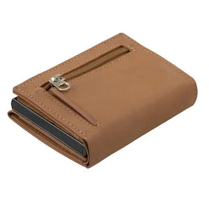 The GARZINI - SLIM TRIFOLD RFID-blocking leather wallet in camel brown is shown open, displaying a blue card, a white card, and a large “NO CASH VALUE” play bill. “GARZINI” is embossed on the left side. Includes metal card holder and coin pocket.