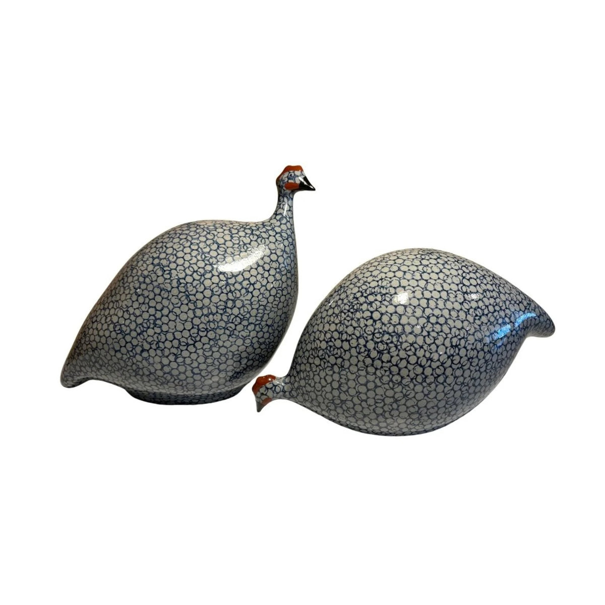 The LES CERAMIQUES DE LUSSAN - LARGE PECKING CERAMIC FRENCH GUINEA IN BLUE SPOTTED COBALT sculpture showcases a pattern of small blue circles on a white background. It is elegantly displayed on a simple, light-colored pedestal against a neutral backdrop, reflecting the artistry of traditional ceramic workshops.