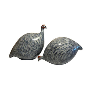 The LES CERAMIQUES DE LUSSAN - LARGE PECKING CERAMIC FRENCH GUINEA IN BLUE SPOTTED COBALT sculpture showcases a pattern of small blue circles on a white background. It is elegantly displayed on a simple, light-colored pedestal against a neutral backdrop, reflecting the artistry of traditional ceramic workshops.