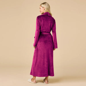 A person wearing a beige SOFTIES - SERENITY WRAP ROBE featuring a wrap silhouette with a tie waist and side pockets.