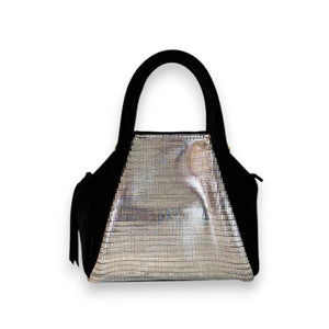 The OLIVEVE Mini Taya Top Handle, crafted from Italian leather in black, boasts a sleek modern design with a metallic front panel reflecting distorted images. This elegant handbag features two handles and stands out against its plain white backdrop.