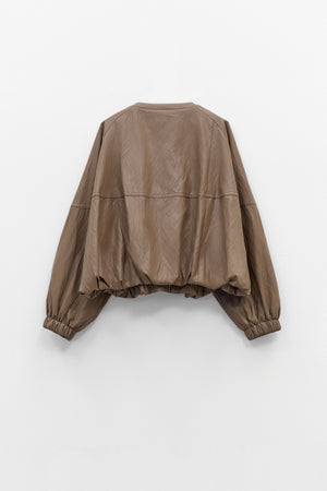 The ELEH - THE MOD BOMBER JACKET by ELEH is a brown leather jacket featuring a sculptural design, front zipper, round neckline, and long oversized sleeves with gathered cuffs, shown against a plain white background.