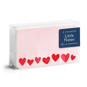 The E. FRANCES - LITTLE NOTES BLUSH MINI HEARTS is a rectangular mini note card with a light pink background and red hearts in various sizes. "Little Notes® by E. FRANCES PAPER" and "Please recycle me." are printed at the bottom.