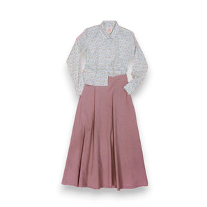 The MARNIE SKIRT by THE LITTLE PROJECT is a mustard yellow A-line design made in Los Angeles. It has a smooth texture, subtle pleats, and a side zipper, and is showcased on a plain white background.